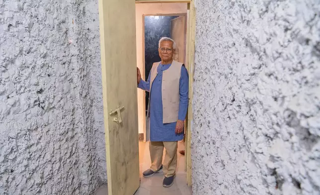 Head of Bangladesh's interim government Muhammad Yunus, center, looks at an exhibit during the inauguration of the July Uprising Memorial Museum, once the official residence of Bangladesh's ousted Prime Minister Sheikh Hasina, in Dhaka, Bangladesh, Tuesday, Jan. 20, 2026. (AP Photo/Mahmud Hossain Opu)