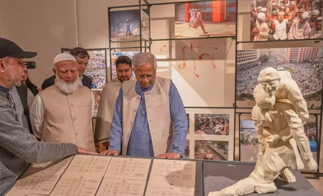 Head of Bangladesh's interim government Muhammad Yunus, center, with Bangladesh Jamaat-e-Islami party leader Ameer Shafiqur Rahman, center left, looks at an exhibit during the inauguration of the July Uprising Memorial Museum, once the official residence of Bangladesh's ousted Prime Minister Sheikh Hasina, in Dhaka, Bangladesh, Tuesday, Jan. 20, 2026. (AP Photo/Mahmud Hossain Opu)