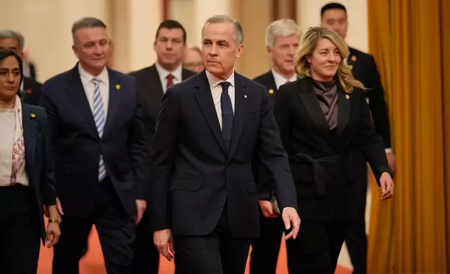 Canada's Prime Minister Mark Carney, center, arrives to meet with Chinese President Xi Jinping, at the Great Hall of the People in Beijing, China, Friday, Jan. 16, 2026. (AP Photo/Vincent Thian, Pool)
