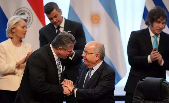 Economic Security Maros Sefcovic, left front, and Brazilian Minister of Foreign Affairs Mauro Vieira greet each other during a meeting to sign a free trade deal between the European Union and Mercosur in Asuncion, Paraguay, Saturday, Jan. 17, 2026. (AP Photo/Jorge Saenz)