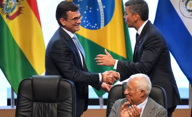 Bolivian President Rodrigo Paz, left, greets Paraguay's President Santiago Pena during a meeting to sign a free trade deal between the European Union and Mercosur, in Asuncion, Paraguay, Saturday, Jan. 17, 2026. (AP Photo/Jorge Saenz)