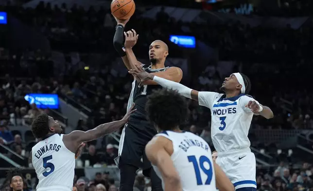San Antonio Spurs forward Victor Wembanyama (1) shoots over Minnesota Timberwolves guard Anthony Edwards (5) during the second half of an NBA basketball game in San Antonio, Saturday, Jan. 17, 2026. (AP Photo/Eric Gay)