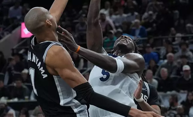 Minnesota Timberwolves guard Anthony Edwards (5) drives to the basket against San Antonio Spurs forward Victor Wembanyama (1) during the second half of an NBA basketball game in San Antonio, Saturday, Jan. 17, 2026. (AP Photo/Eric Gay)
