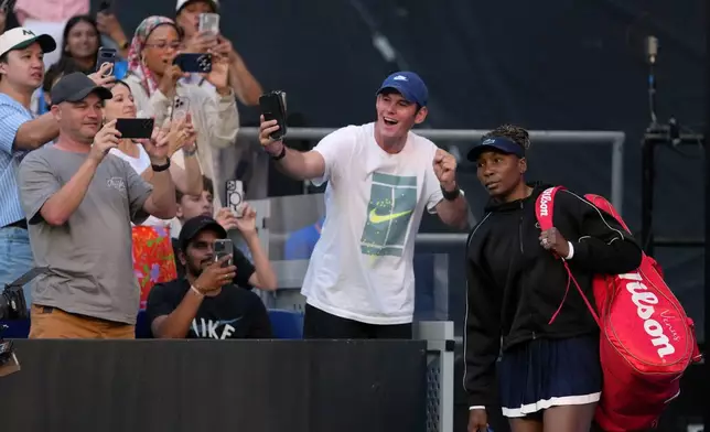 Spectators takes photos of Venus Williams of the U.S. as she walks onto court for her first round match against Olga Danilovic of Serbia at the Australian Open tennis championship in Melbourne, Australia, Sunday, Jan. 18, 2026. (AP Photo/Aaron Favila)