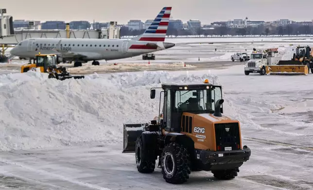 Snow and ice is cleared at Ronald Reagan Washington National Airport, Monday morning, Jan. 26, 2026, in Arlington, Va. (AP Photo/Julia Demaree Nikhinson)
