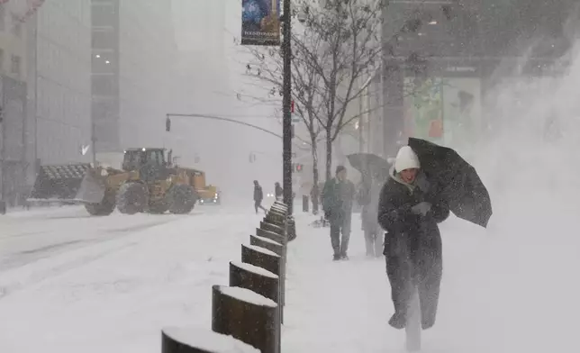 Pedestrians walk down Fifth Avenue during a winter storm, Sunday, Jan. 25, 2026, in New York. (AP Photo/Heather Khalifa)
