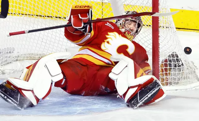 Calgary Flames goalie Dustin Wolf makes a save against the Anaheim Ducks during first-period NHL hockey game action in Calgary, Alberta, Sunday, Jan. 25, 2026. (Larry MacDougal/The Canadian Press via AP)
