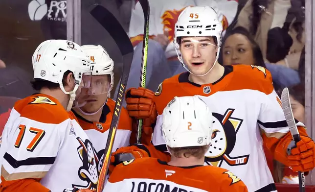 Anaheim Ducks Beckett Sennecke (45) celebrates after his goal against the Calgary Flames with teammates Alex Killorn (17), Mikael Granlund, second from left, and Jackson LaCombe (2) during second-period NHL hockey game action in Calgary, Alberta, Sunday, Jan. 25, 2026. (Larry MacDougal/The Canadian Press via AP)