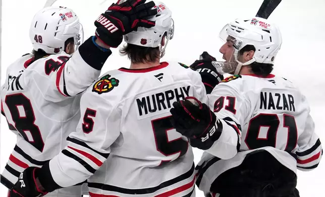 Chicago Blackhawks defenseman Connor Murphy (5) celebrates with Frank Nazar and Matt Grzelcyk after scoring during the first period of an NHL hockey game against the Pittsburgh Penguins in Pittsburgh, Thursday, Jan. 29, 2026. (AP Photo/Gene J. Puskar)