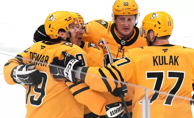 Pittsburgh Penguins' Connor Dewar, left, celebrates after his goal during the first period of an NHL hockey game against the Chicago Blackhawks in Pittsburgh, Thursday, Jan. 29, 2026. (AP Photo/Gene J. Puskar)