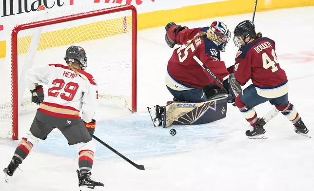 Ottawa Charge's Peyton Hemp (29) moves in on Montreal Victoire goaltender Ann-Renee Desbiens (35) as Victoire's Amanda Boulier (44) defends during second period PWHL hockey action in Laval, Que., Tuesday, Jan. 13, 2026. (Graham Hughes/The Canadian Press via AP)