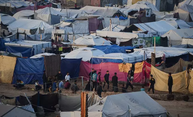 Young Palestinians play volleyball at a tent camp housing displaced families in Deir al-Balah, in the central Gaza Strip, Saturday, Jan. 10, 2026. (AP Photo/Abdel Kareem Hana)
