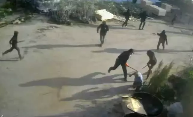 This frame grab from security camera footage filmed Jan. 8, 2025, and obtained by The Associated Press, shows men dressed mostly in black with their faces covered, two of whom are hitting a man on the ground as he tried to flee a nursery in the northern West Bank village of Deir Sharaf. Two people who witnessed the attack and are members of the family that owns the facility said the assailants were Israeli settlers beating 67-year-old Basim Saleh Yassin.(UGC via AP)