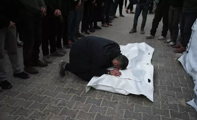 Palestinians mourn the body of Saeed Al-Jaro, killed in an Israeli military strike, during his funeral at Al-Aqsa Hospital in Deir al-Balah, Gaza Strip Thursday, Jan. 15, 2026. (AP Photo/Abdel Kareem Hana)