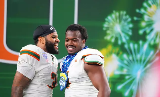 Miami defensive lineman Akheem Mesidor, left, and defensive lineman Rueben Bain Jr. react following the Cotton Bowl College Football Playoff quarterfinal game against Ohio State Wednesday, Dec. 31, 2025, in Arlington, Texas. (AP Photo/Julio Cortez)