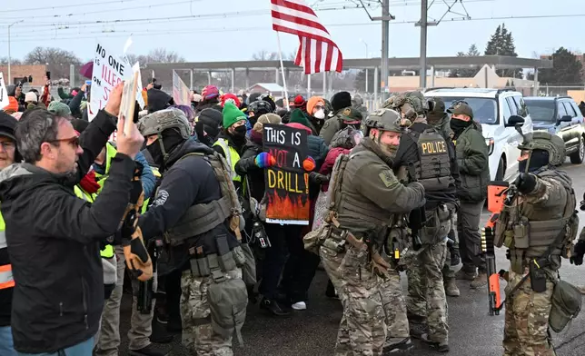 Protesters confront federal agents outside the Bishop Henry Whipple Federal Building, Thursday, Jan. 8, 2026, in Minneapolis, Minn. (AP Photo/Tom Baker)