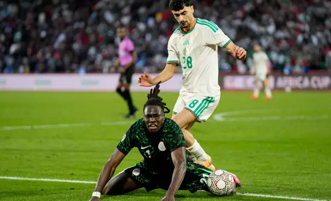 Nigeria's Calvin Bassey, front, and Algeria's Redouane Berkane challenge for the ball during the Africa Cup of Nations quarterfinal soccer match between Nigeria and Algeria, in Marrakech, Morocco, Saturday, Jan. 10, 2026. (AP Photo/Themba Hadebe)
