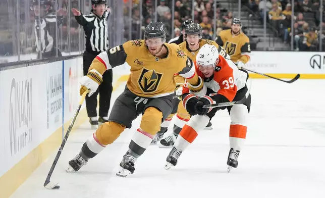 Vegas Golden Knights defenseman Jeremy Lauzon (5) skates with the puck against Philadelphia Flyers right wing Matvei Michkov (39) during the second period of an NHL hockey game Monday, Jan. 19, 2026, in Las Vegas. (AP Photo/Candice Ward)