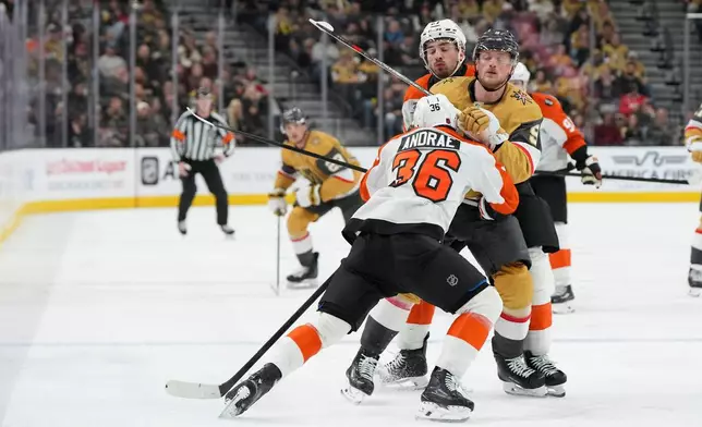 Philadelphia Flyers defenseman Emil Andrae (36) and left wing Noah Cates (27) defend against Vegas Golden Knights center Jack Eichel (9) during the second period of an NHL hockey game Monday, Jan. 19, 2026, in Las Vegas. (AP Photo/Candice Ward)