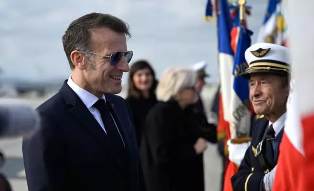 French President Emmanuel Macron, speaks with flag bearers as he visits the Istres military air force base, southern France, Thursday, Jan. 15, 2026. (AP Photo/Philippe Magoni, Pool)