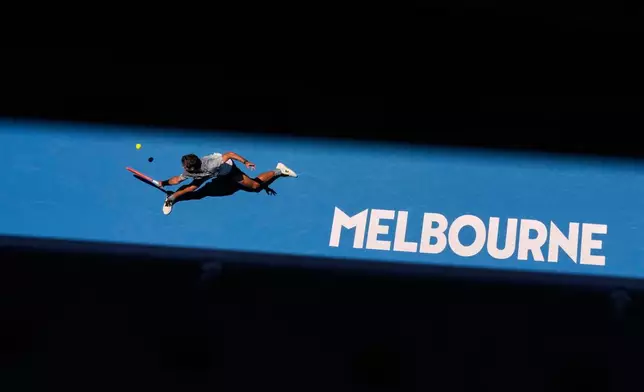 Flavio Cobolli of Italy plays a backhand return to Arthur Fery of Britain during their first round match at the Australian Open tennis championship in Melbourne, Australia, Sunday, Jan. 18, 2026. (AP Photo/Aaron Favila)