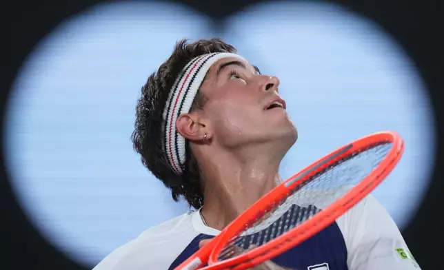 Francisco Comesana of Argentina plays a forehand return to Frances Tiafoe of the U.S. during their second round match at the Australian Open tennis championship in Melbourne, Australia, Wednesday, Jan. 21, 2026. (AP Photo/Asanka Brendon Ratnayake)