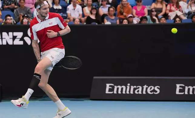 Alexander Bublik of Kazakhstan plays a shot between his legs to Marton Fucsovics of Hungary during their second round match at the Australian Open tennis championship in Melbourne, Australia, Wednesday, Jan. 21, 2026. (AP Photo/Dita Alangkara)