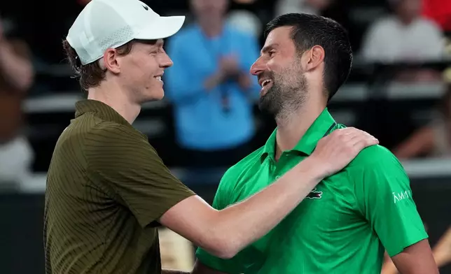 Novak Djokovic, right, of Serbia is congratulated by Jannik Sinner, left, of Italy following their semifinal match at the Australian Open tennis championship in Melbourne, Australia, early Saturday, Jan. 31, 2026. (AP Photo/Aaron Favila)
