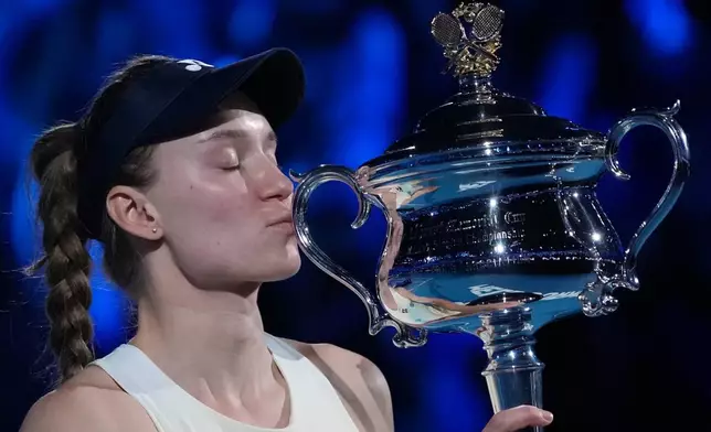 Elena Rybakina of Kazakhstan kisses the Daphne Akhurst Memorial Cup after defeating Aryna Sabalenka of Belarus to win the women's singles final at the Australian Open tennis championship in Melbourne, Australia, Saturday, Jan. 31, 2026. (AP Photo/Aaron Favila)