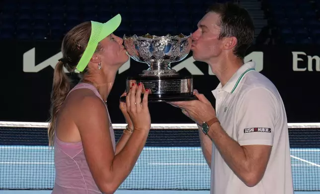 Australia's Olivia Gadecki and John Peers kiss their trophy after defeating France's Kristina Mladenovic and Manuel Guinard in the mixed doubles final at the Australian Open tennis championship in Melbourne, Australia, Friday, Jan. 30, 2026. (AP Photo/Dita Alangkara)