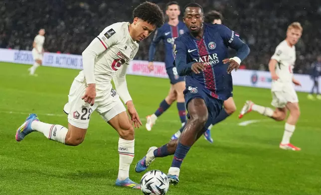 Lille's Tiago Santos, left, challenges for the ball with PSG's Willian Pacho during the French League One soccer match between Paris Saint-Germain and Lille in Paris, France, Friday, Jan. 16, 2026. (AP Photo/Michel Euler)