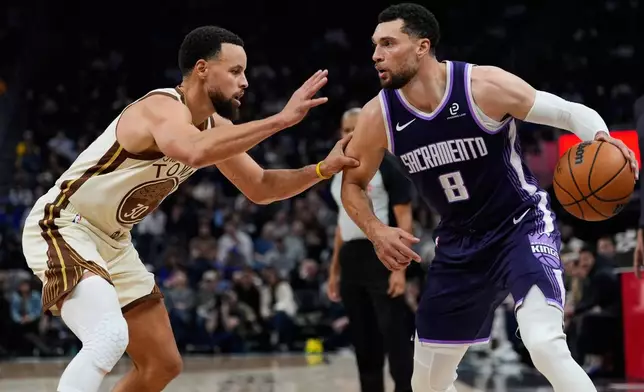 Sacramento Kings guard Zach LaVine (8) moves the ball while defended by Golden State Warriors guard Stephen Curry (30) during the first half of an NBA basketball game, Friday, Jan. 9, 2026, in San Francisco. (AP Photo/Godofredo A. Vásquez)