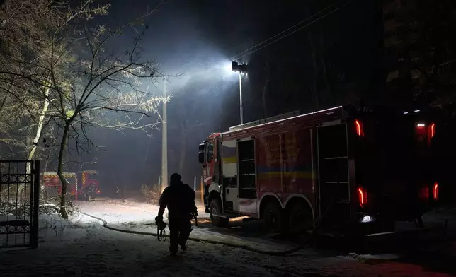 Rescue workers put out a fire at a residential building damaged by a Russian strike in Kyiv, Ukraine, Friday, Jan. 9, 2026. (AP Photo/Efrem Lukatsky)