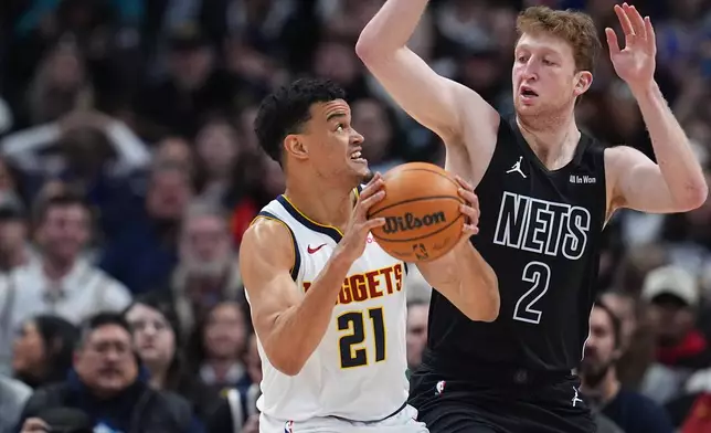 Denver Nuggets forward Spencer Jones, left, goes up for a shot as Brooklyn Nets forward Danny Wolf defends in the first half of an NBA basketball game, Thursday, Jan. 29, 2026, in Denver. (AP Photo/David Zalubowski)