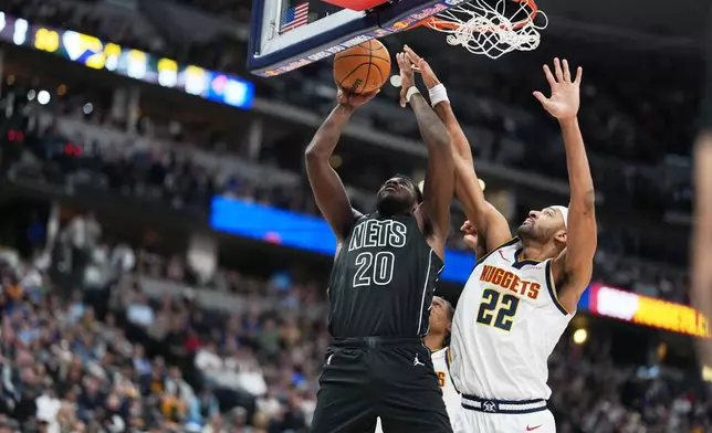Denver Nuggets center Zeke Nnaji, right, goes up to block a shot by Brooklyn Nets center Day'ron Sharpe in the first half of an NBA basketball game Thursday, Jan. 29, 2026, in Denver. (AP Photo/David Zalubowski)