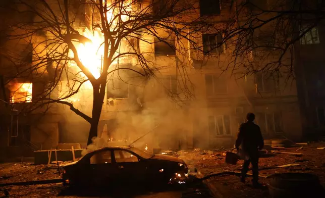 FILE - A man walks in front of burning residential building after a Russian attack on Zaporizhzhia, Ukraine, Nov. 26, 2025. (AP Photo/Kateryna Klochko, File)