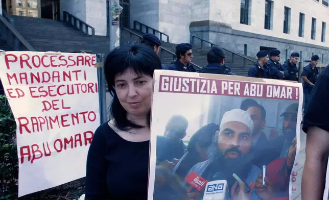 FILE - A protester holds up a poster with writing reading in Italian "Justice for Abu Omar" above a picture of Muslim cleric Osama Moustafa Hassan Nasr, also known as Abu Omar, outside Milan's court house while the trial of 26 Americans and seven Italians accused of orchestrating a CIA-led kidnapping of an Egyptian terror suspect Nasr was taking place inside the courtroom, in Milan, Italy, Wednesday, Sept. 23, 2009. (AP Photo/Luca Bruno, File)