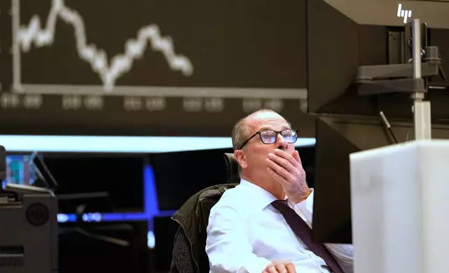 FILE - A trader sits on the trading floor of the Frankfurt Stock Exchange in front of the display board showing the DAX stock index in Frankfurt, Germany, April 9, 2025. (AP Photo/Martin Meissner, File)