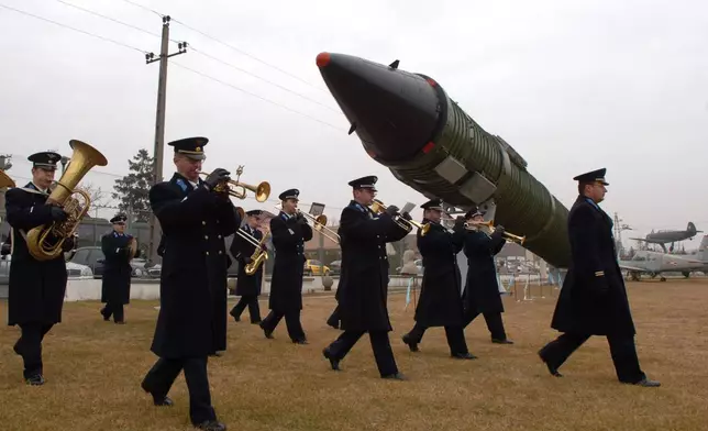 FILE - A Hungarian military orchestra marches through the site of the new spectacle, a Soviet SS-24 intercontinental ballistic missile, erected by the Technical Museum of War in Kecel, Hungary, 160 km south of Budapest Tuesday, Nov. 15. 2005. (AP Photo/Bela Szandelszky, File)