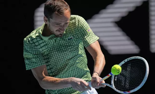 Daniil Medvedev of Russia plays a backhand return to Fabian Marozsan of Hungary during their third round match at the Australian Open tennis championship in Melbourne, Australia, Friday, Jan. 23, 2026. (AP Photo/Dita Alangkara)