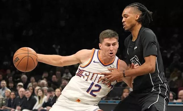Brooklyn Nets' Ziaire Williams, right, defends Phoenix Suns' Collin Gillespie during the first half of an NBA basketball game Monday, Jan. 19, 2026, in New York. (AP Photo/Frank Franklin II)