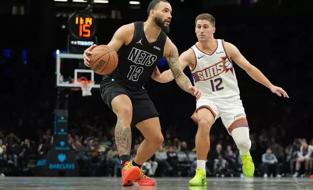 Phoenix Suns' Collin Gillespie (12) defends Brooklyn Nets' Tyrese Martin (13) during the second half of an NBA basketball game Monday, Jan. 19, 2026, in New York. (AP Photo/Frank Franklin II)