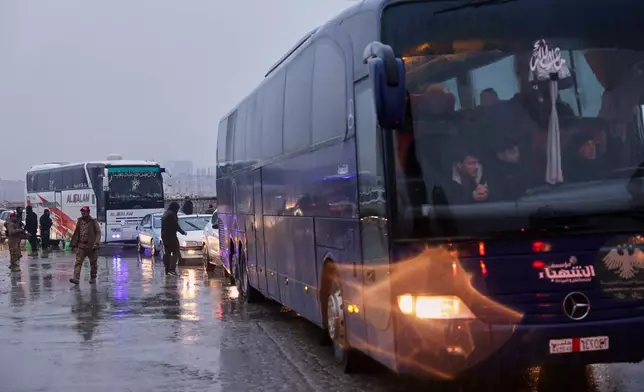 Buses carry displaced residents as they return to the Achrafieh neighborhood after days of fighting between government forces and Kurdish fighters in the northern city of Aleppo, Syria, Monday, Jan. 12, 2026. (AP Photo/Ghaith Alsayed)