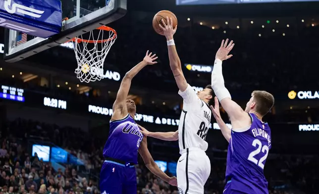 Utah Jazz center Kyle Filipowski (22) and forward Cody Williams (5) defend against Brooklyn Nets guard Nolan Traore (88) who goes up to shoot during the second half of an NBA basketball game, Friday, Jan. 30, 2026, in Salt Lake City. (AP Photo/Anna Fuder)