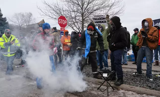 People cover tear gas deployed by federal immigration officers outside Bishop Henry Whipple Federal Building, Thursday, Jan. 15, 2026, in Minneapolis. (AP Photo/Adam Gray)