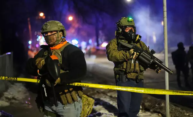 Law enforcement officers at the scene of a reported shooting Wednesday, Jan. 14, 2026, in Minneapolis. (AP Photo/Adam Gray)