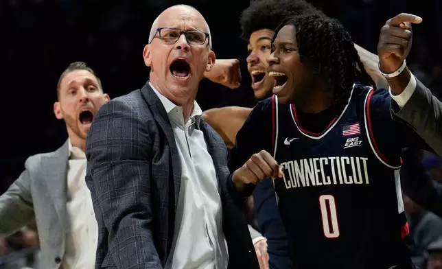 UConn head coach Dan Hurley, left, and guard Malachi Smith (0) celebrate during the second half of an NCAA college basketball game against Xavier, Wednesday, Dec. 31, 2025, in Cincinnati. (AP Photo/Carolyn Kaster)
