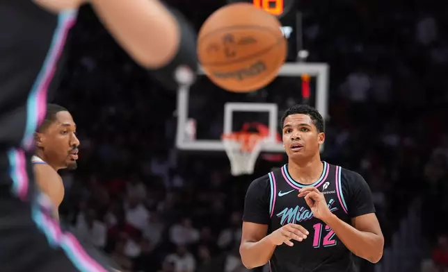 Miami Heat guard Dru Smith (12) passes the ball during the first half of an NBA basketball game against the Oklahoma City Thunder, Saturday, Jan. 17, 2026, in Miami. (AP Photo/Rebecca Blackwell)