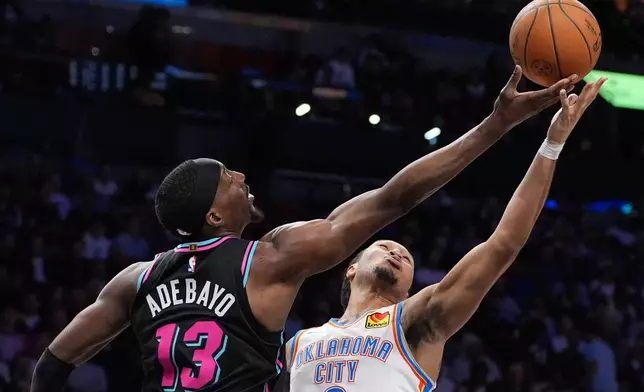 Miami Heat center Bam Adebayo (13) and Oklahoma City Thunder forward Jaylin Williams (6) battle for a rebound during the first half of an NBA basketball game, Saturday, Jan. 17, 2026, in Miami. (AP Photo/Rebecca Blackwell)