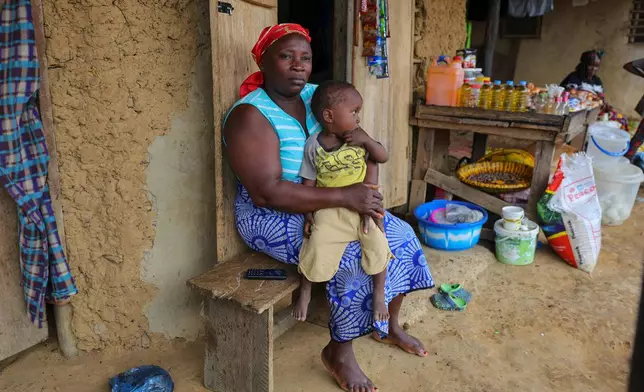 Fatama Massaley holds the son of Essah Massaley, who died during a protest in Kinjor, Liberia, July 8, 2025. (AP Photo/Misper Apawu)